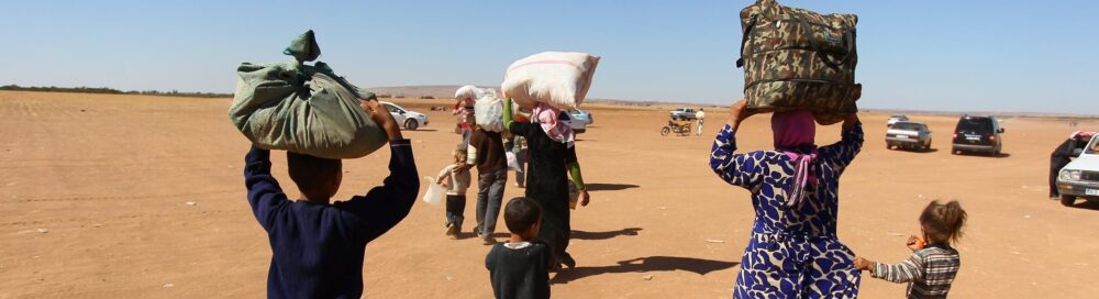 A Syrian Kurdish family, fled from clashes between ISIL militants and PYD forces, carry their belongings_picture alliance.