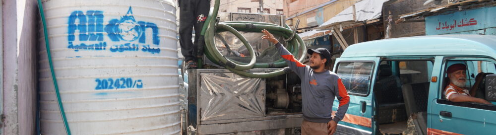 A worker filling a residents' water tank in Al-Ma’alla District, Yemen.