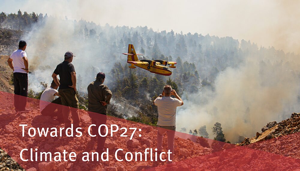 Locals look at burning forest during a wildfire in Greece