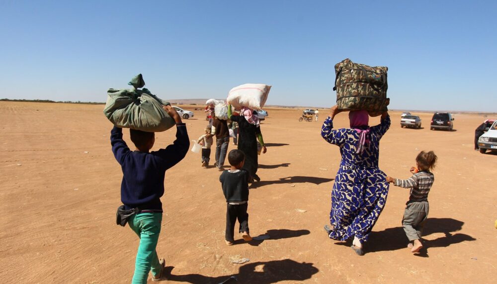 A Syrian Kurdish family, fled from clashes between ISIL militants and PYD forces, carry their belongings_picture alliance.