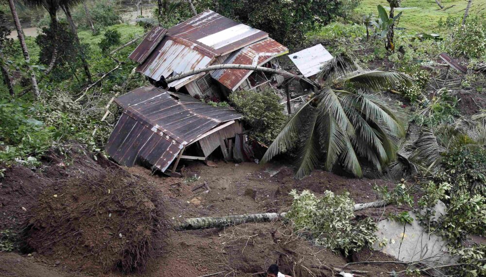 A man walks near houses swept away by landslides in Sibagat, Agusan del Sur in the southern Philippine island of Mindanao.
