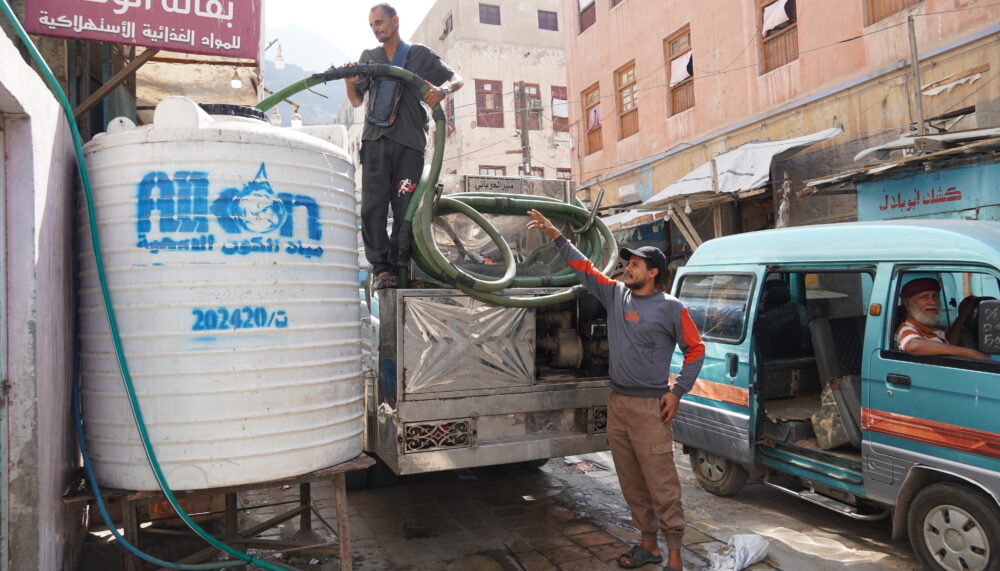 A worker filling a residents' water tank in Al-Ma’alla District, Yemen.