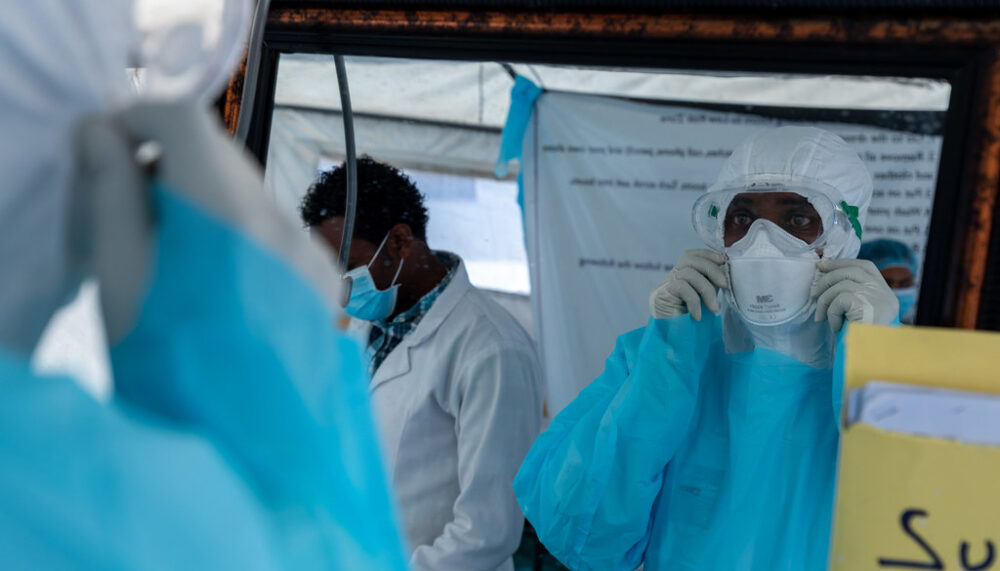 Health care workers inspect their personal protective equipment before interacting with a patient suspected of having COVID-19 at Bole-Chefe isolation center on 9 April 2020.