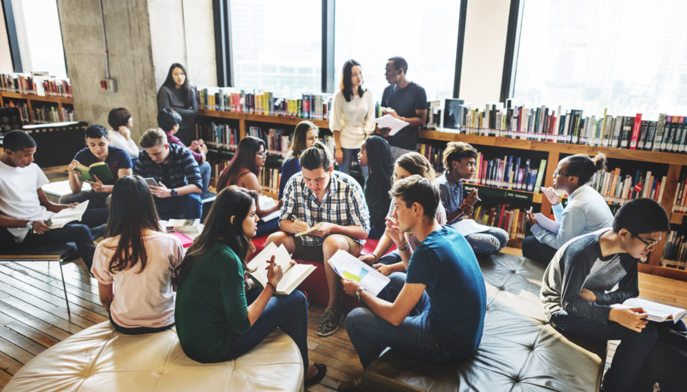 Students sitting in small groups at a library