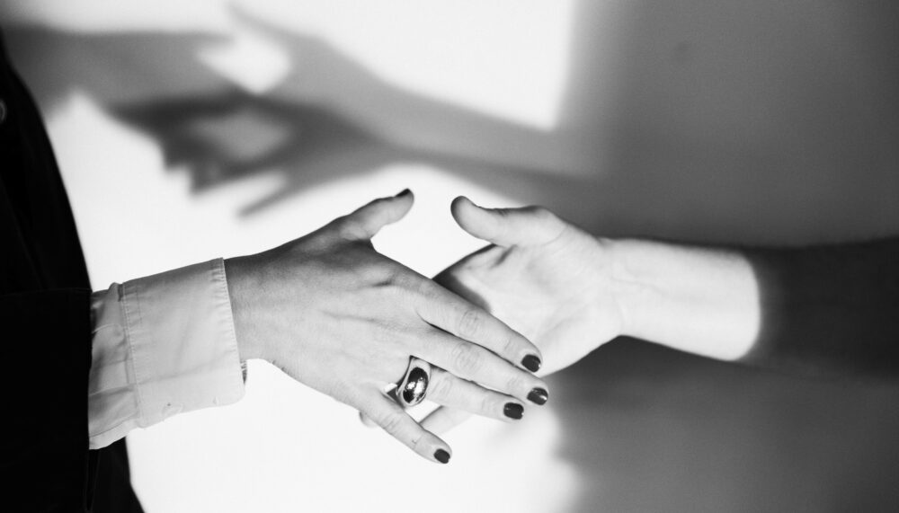 Abstract image of two women holding hands.